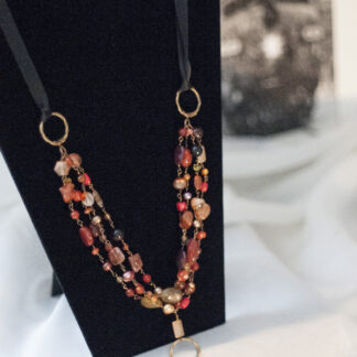 long shot of cheryll's long necklace with glass flame